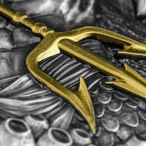 Gold anchor on a detailed silver coin surface, symbolizing maritime heritage.