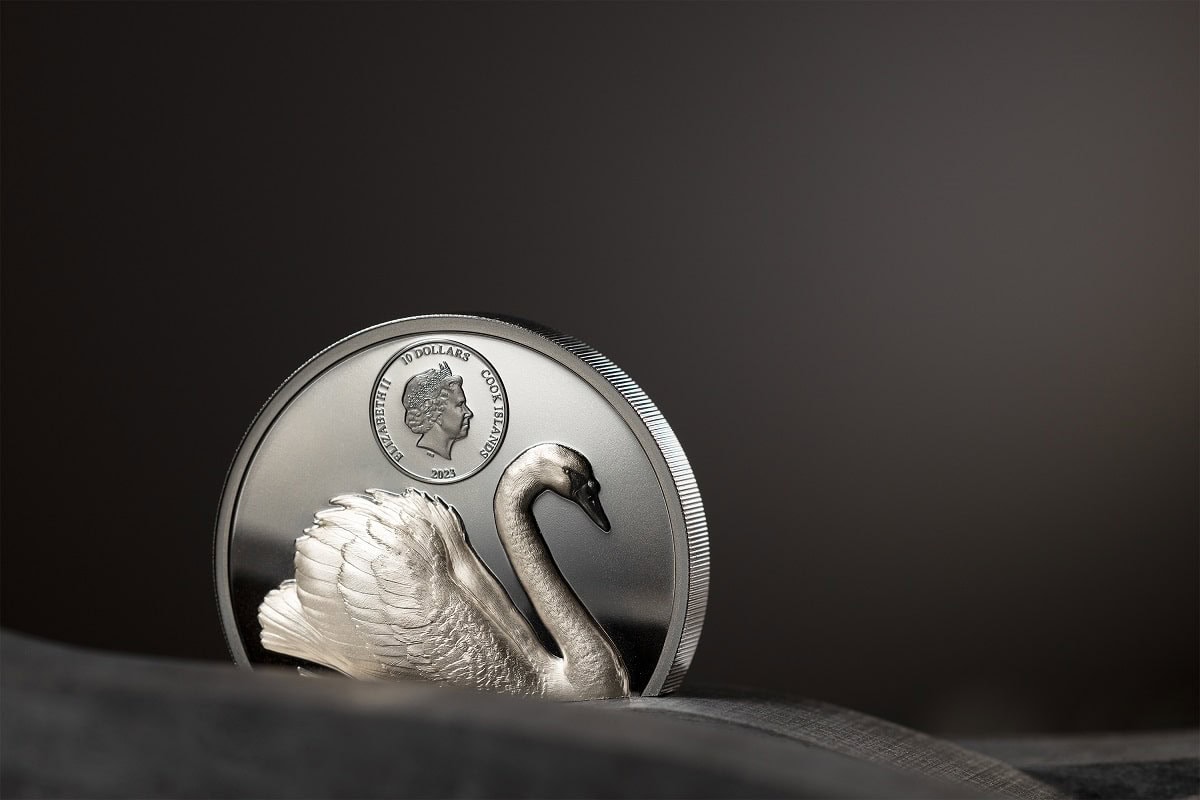 Swan-shaped silver collectible coin with Queen Elizabeth II's profile, 2023, from Cook Islands, on a dark background.