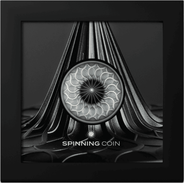 Shiny silver spinning coin with geometric pattern in a black shadow box.
