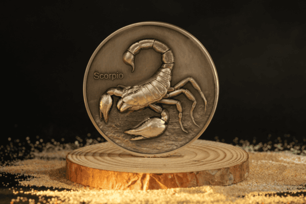 Scorpio zodiac coin with detailed scorpion image, gold tone, on wooden stand, 2023 collectible astrology coin from GR Reserve.