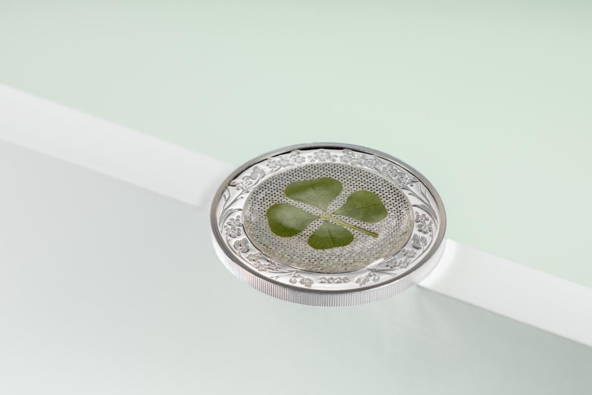 Four-leaf clover engraved on a 2020 coin from Ireland, featuring intricate floral borders and detailed craftsmanship, set against a light-colored background for collectible coin display.