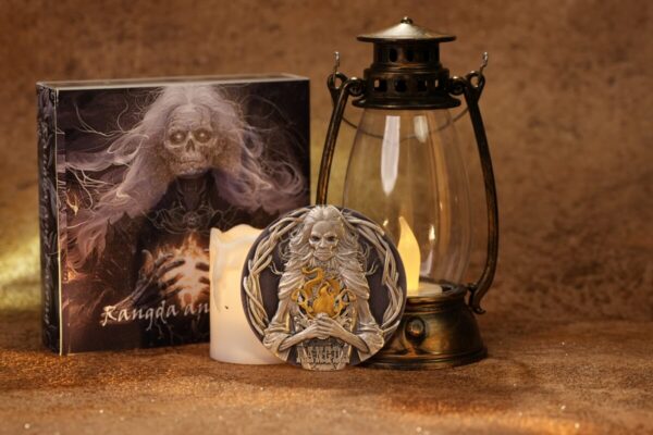 Ornamental collectible coin featuring a mythological character with long flowing hair and a staff, with a box and candle in the background.