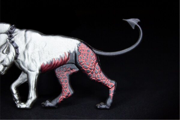 Close-up of the 2025 Cerberus silver stacker’s tail, showing sculpted scales, curled form, and antiqued silver texture with colorized accents.
