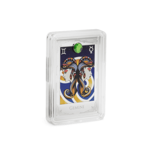 Gemini zodiac coin featuring stylized twin women with colorful hair and intricate designs, encased in a protective display case, with a green gemstone at the top.