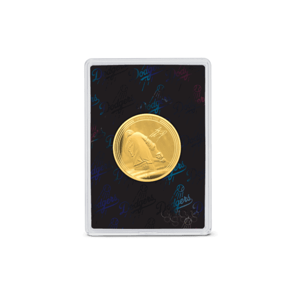 A small, black display case with a gold-colored coin inside. The coin has an embossed circular pattern and the Major League Baseball logo.