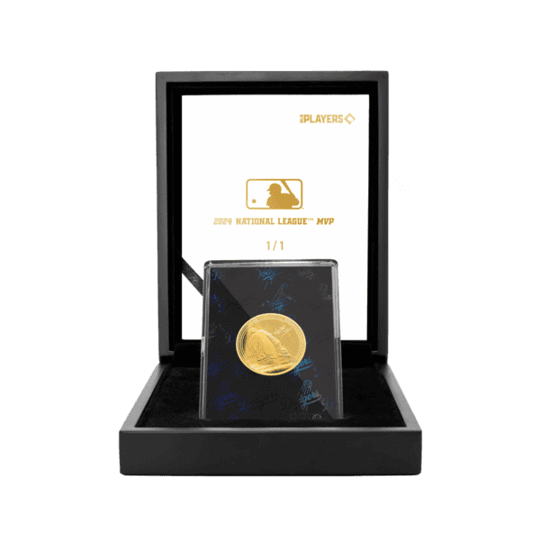 A black collector's box with its lid propped open, revealing a single gold-colored coin inside. The coin has a logo on it, and the case has a circular indentation to hold the coin.