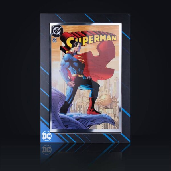 Retail packaging front for the 2025 Samoa DC Comics Superman 204 Iconic Covers Silver Foil featuring full-color rooftop artwork of Superman flying with cape against cityscape background; “Superman” title at top, black backdrop with blue geometric patterns and “DC” logo.