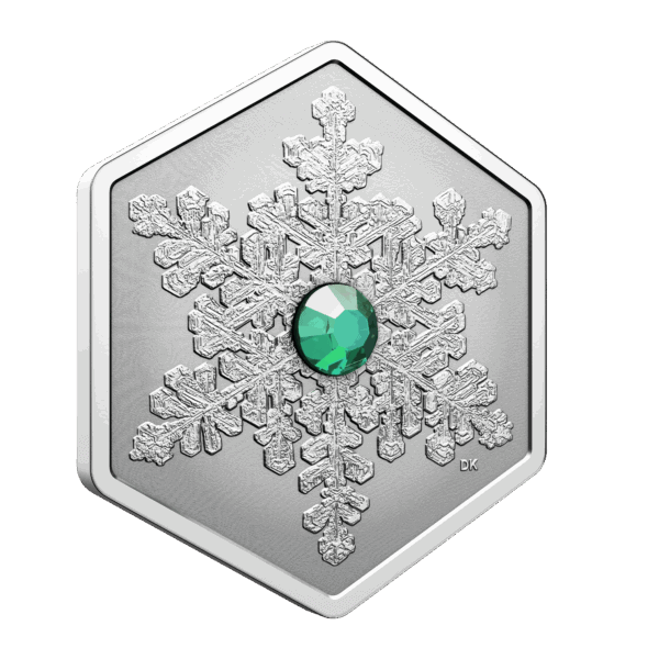 Angled view of hexagonal silver coin featuring snowflake design with green crystal insert