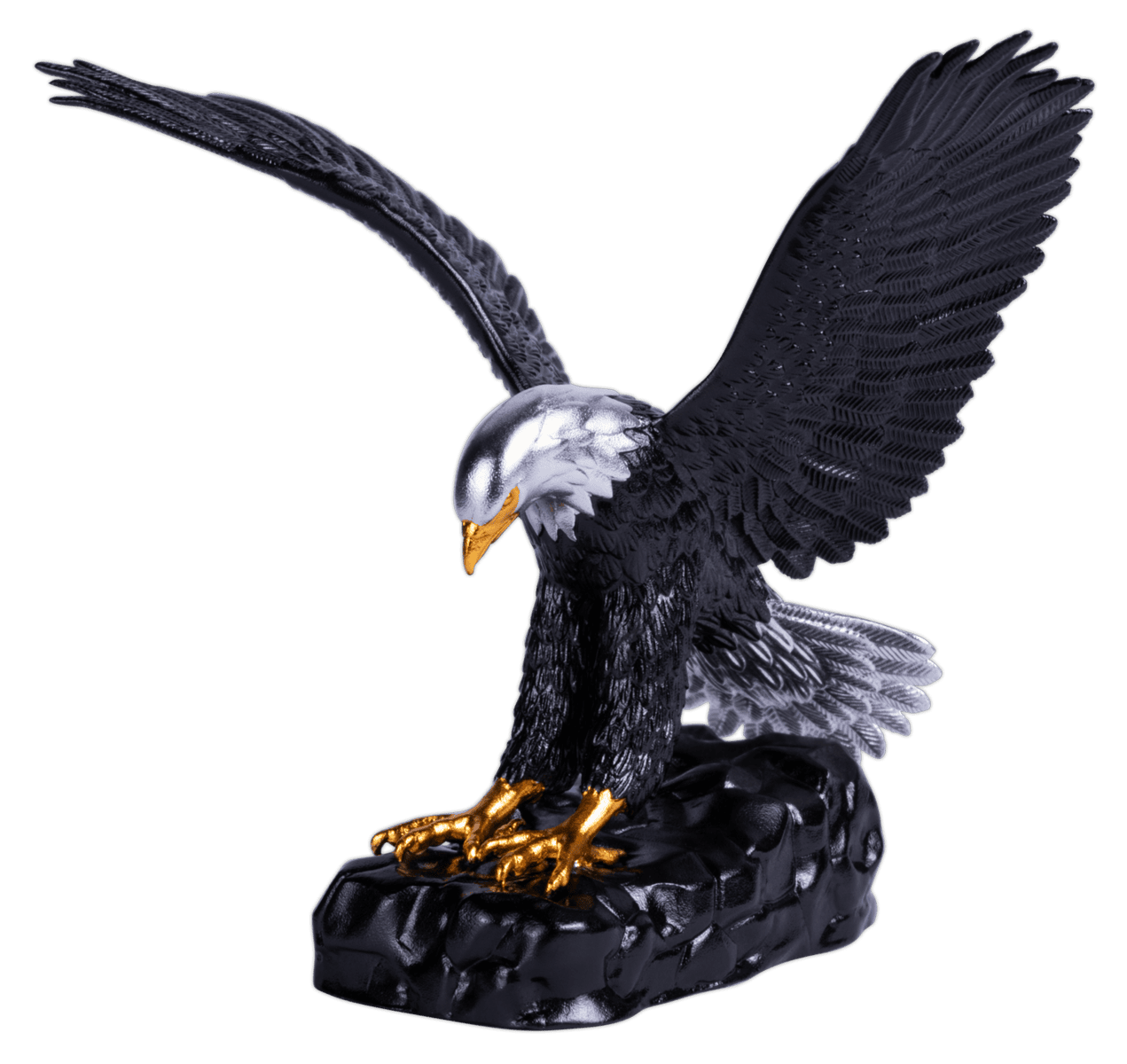 A three-dimensional coin shaped like an eagle, with one wing raised high and the other slightly lower. The eagle's body is dark and colorized, while its beak and talons are gilded gold. The coin rests on a dark, rocky base.
