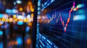 A close-up of a computer monitor displaying financial stock charts with red and blue lines, indicating market trends.