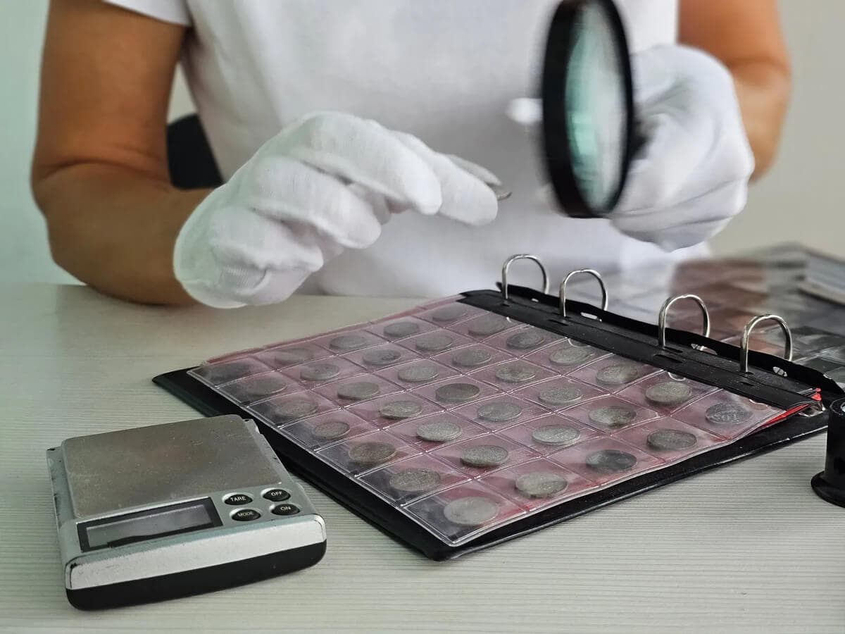 Proper coin grading setup showing lighting, magnification, and reference materials