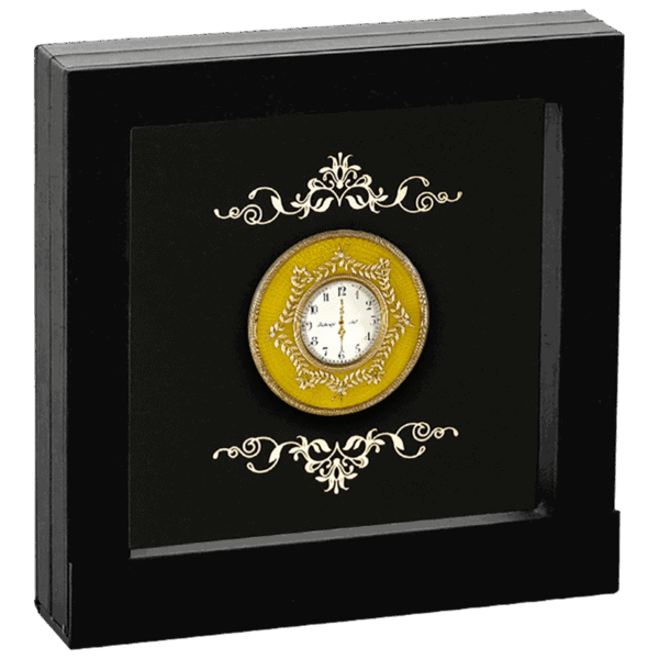 Gold ornate pocket watch with intricate design, set inside a black display box, accented with elegant white scrollwork.