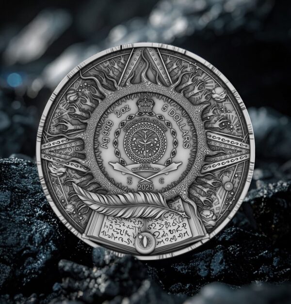 A close-up photograph of the back of a coin featuring a detailed circular relief design, including a central crest, an open book, and feathers, set against a blurred, dark, and rocky background.