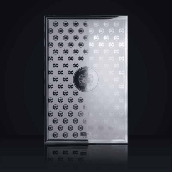 The reverse side of a silver foil note with a repeating DC Comics logo pattern, displayed in a protective case.