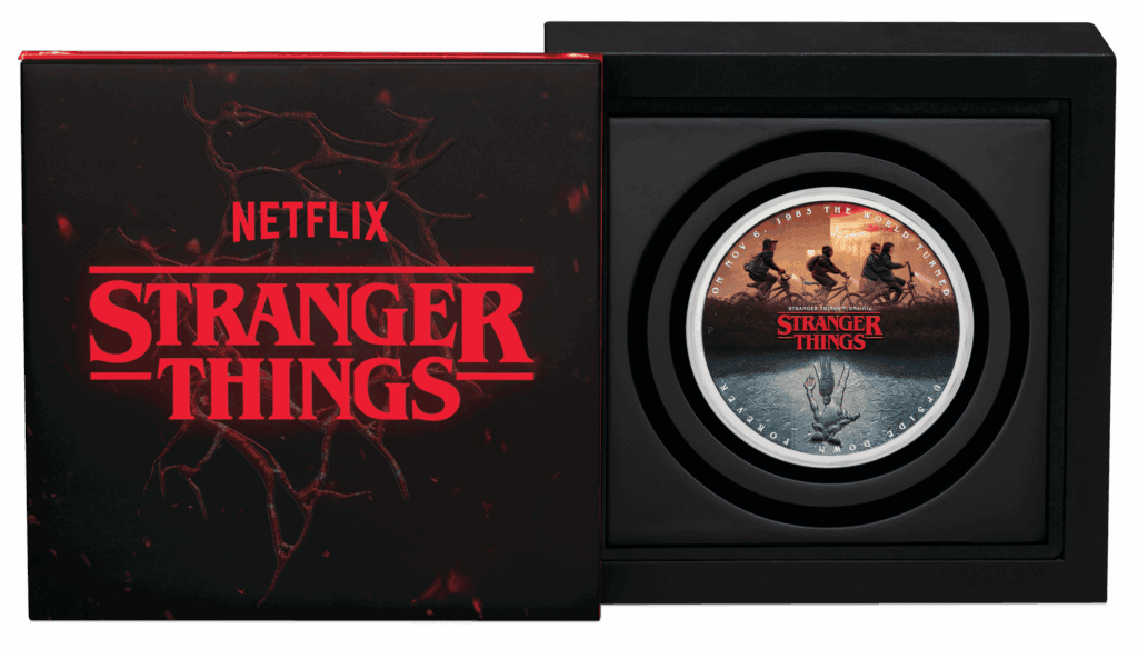 Haunting Stranger Things collectible coin featuring the show's logo and characters riding bikes, in a display case, celebrating the popular 1983 series with intricate design.
