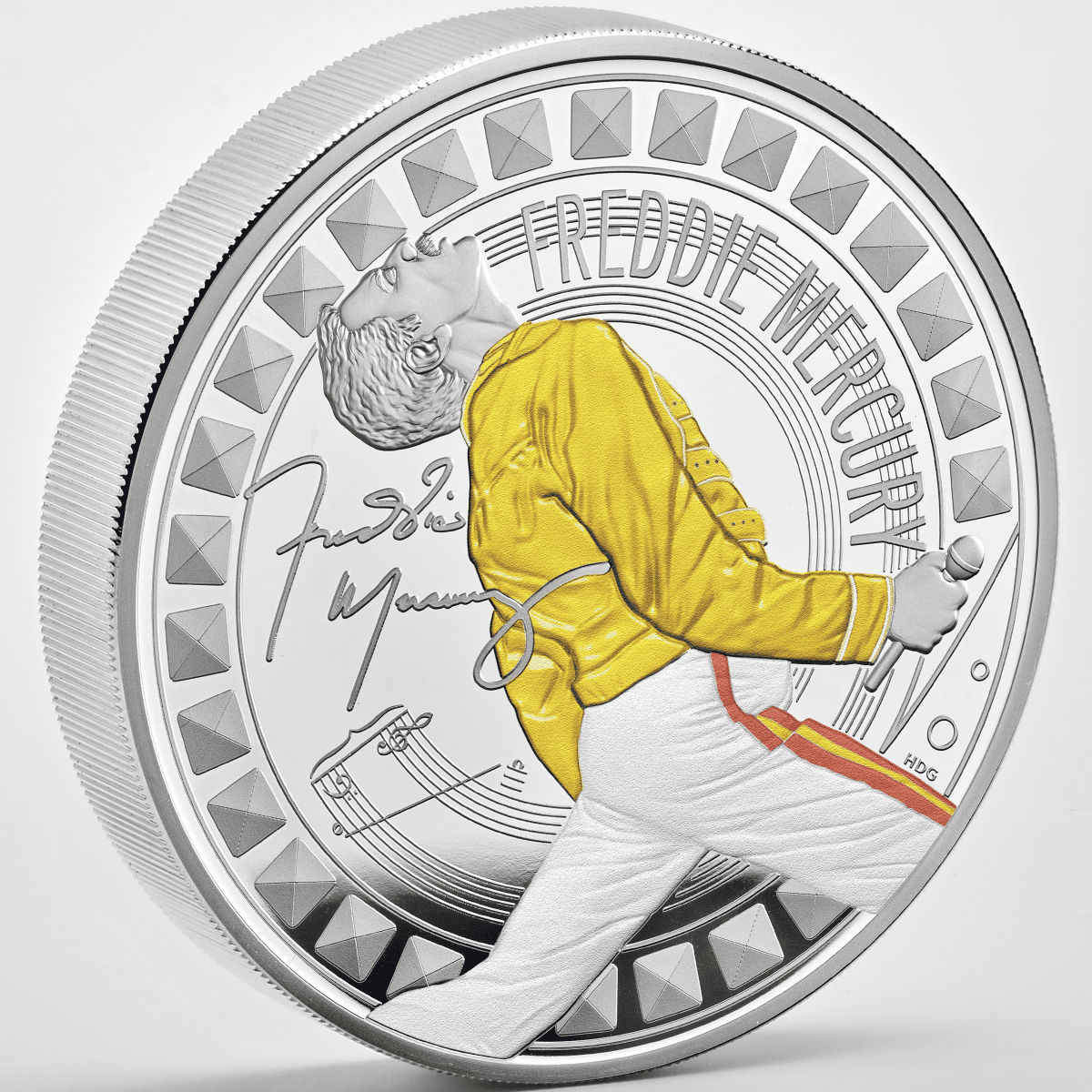 Gold and silver collectible coin featuring Freddie Mercury in iconic pose, detailed engraving, and signature.
