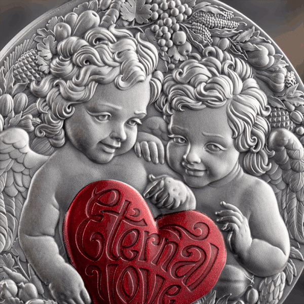 V-Day cherub design silver collectible coin with red heart and "Cherished Love" inscription.