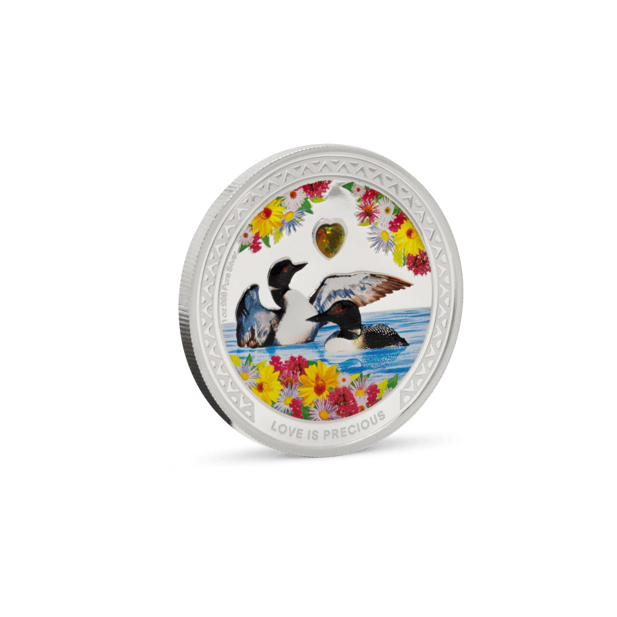 Colorful collectible coin featuring two ducks swimming in water, surrounded by vibrant flowers and a heart-shaped gemstone, with the inscription "LOVE IS PRECIOUS" at the bottom.