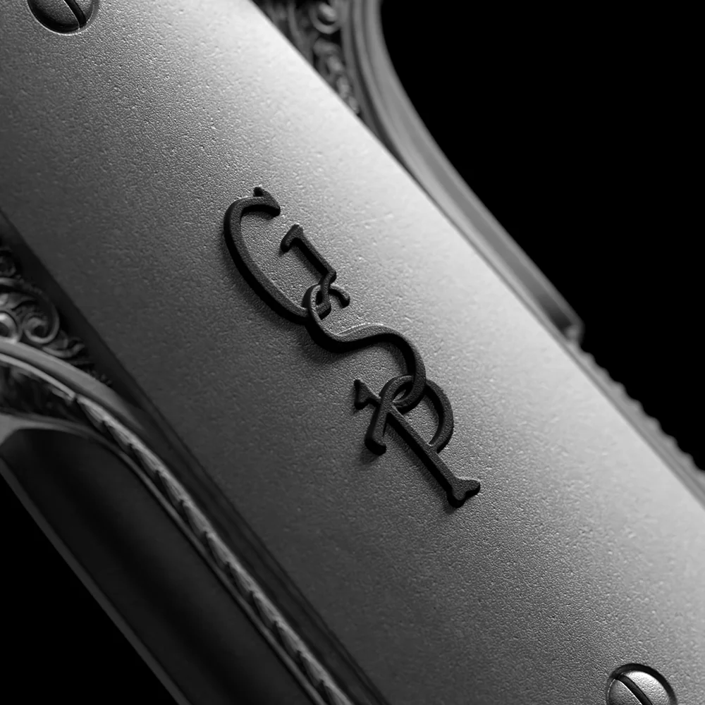 Vintage gun detail with "GR" initials engraved, featuring textured matte finish and ornate metal accents. Perfect for collectors.