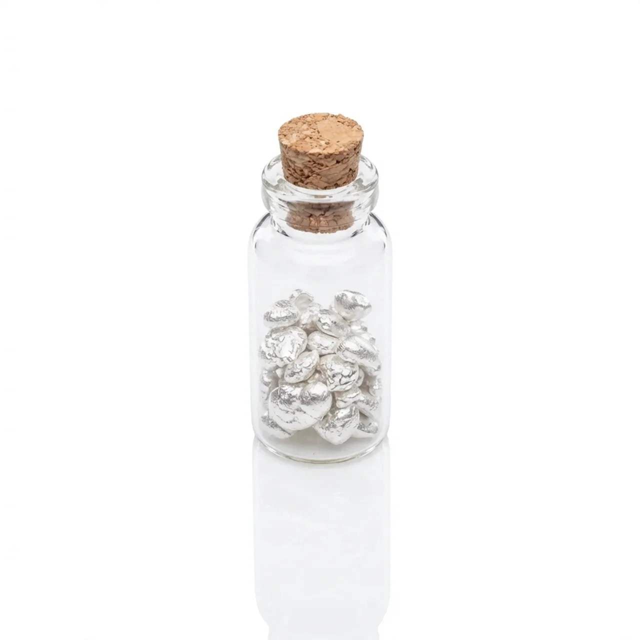 Shiny silver grains in a small glass vial with cork stopper, 10 grams of .999 pure silver, captured from a top-angl.