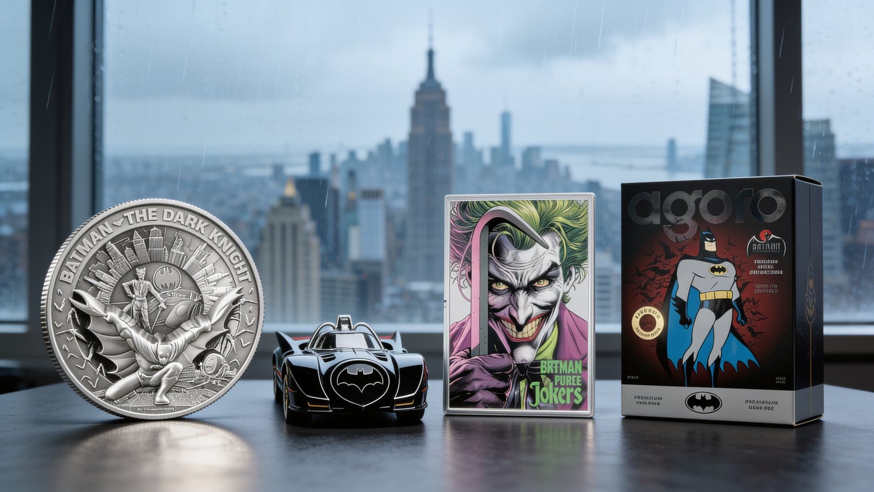 Premium Batman silver collectibles including a large silver coin, Batmobile-shaped coin, foil, and boxed modern release arranged by a city window