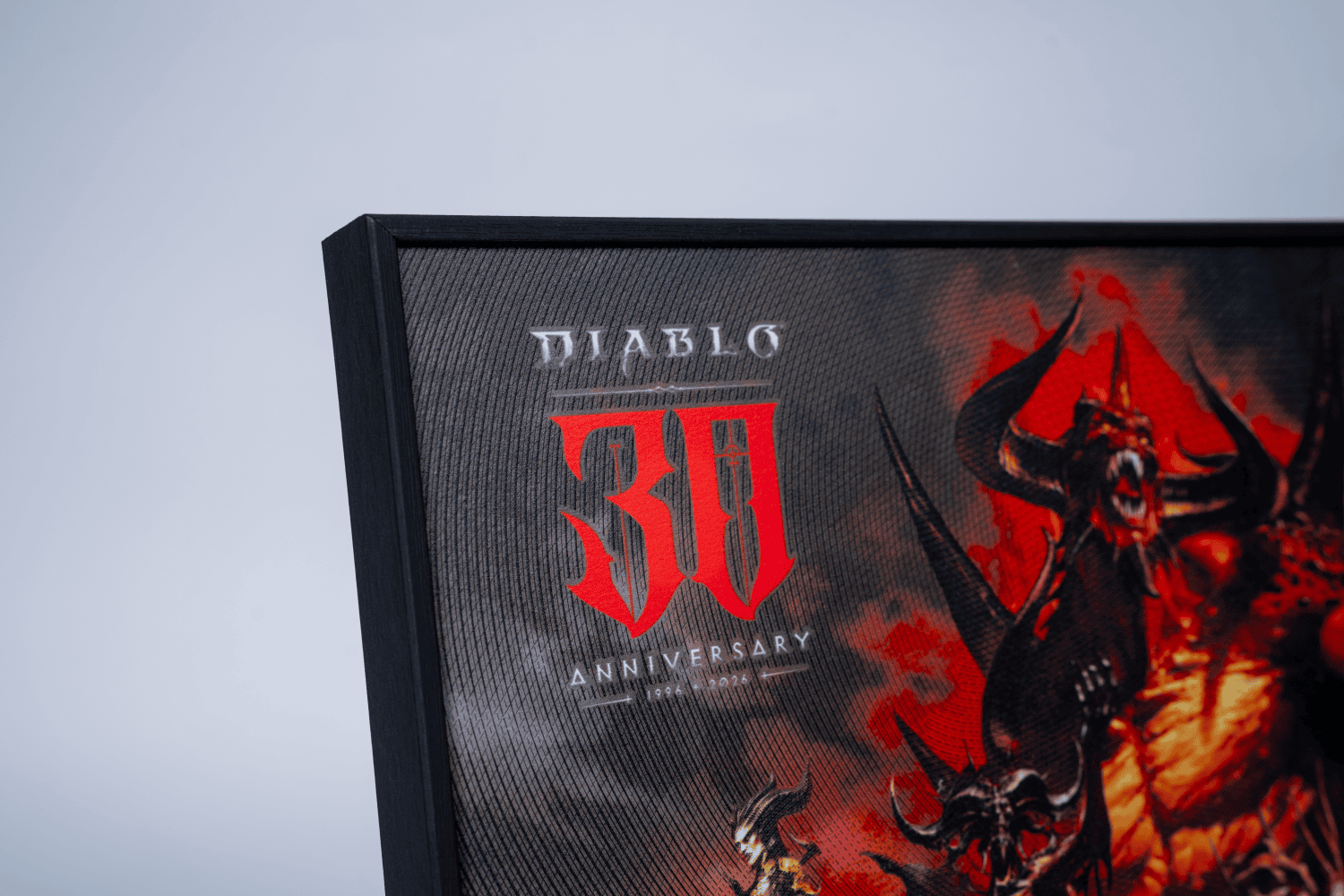 Close crop of the Diablo 30th Anniversary color intaglio print corner, red 30 logo and black frame edge